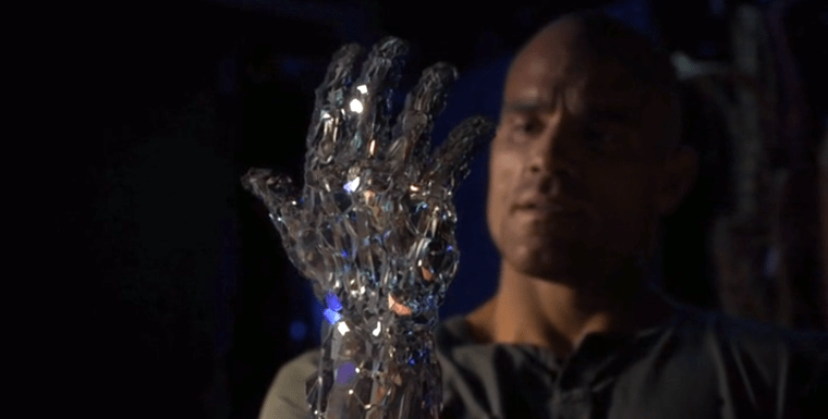 A man looking at his own hand which is becoming crystal.