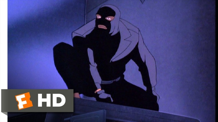 A masked man crouching in the dark.